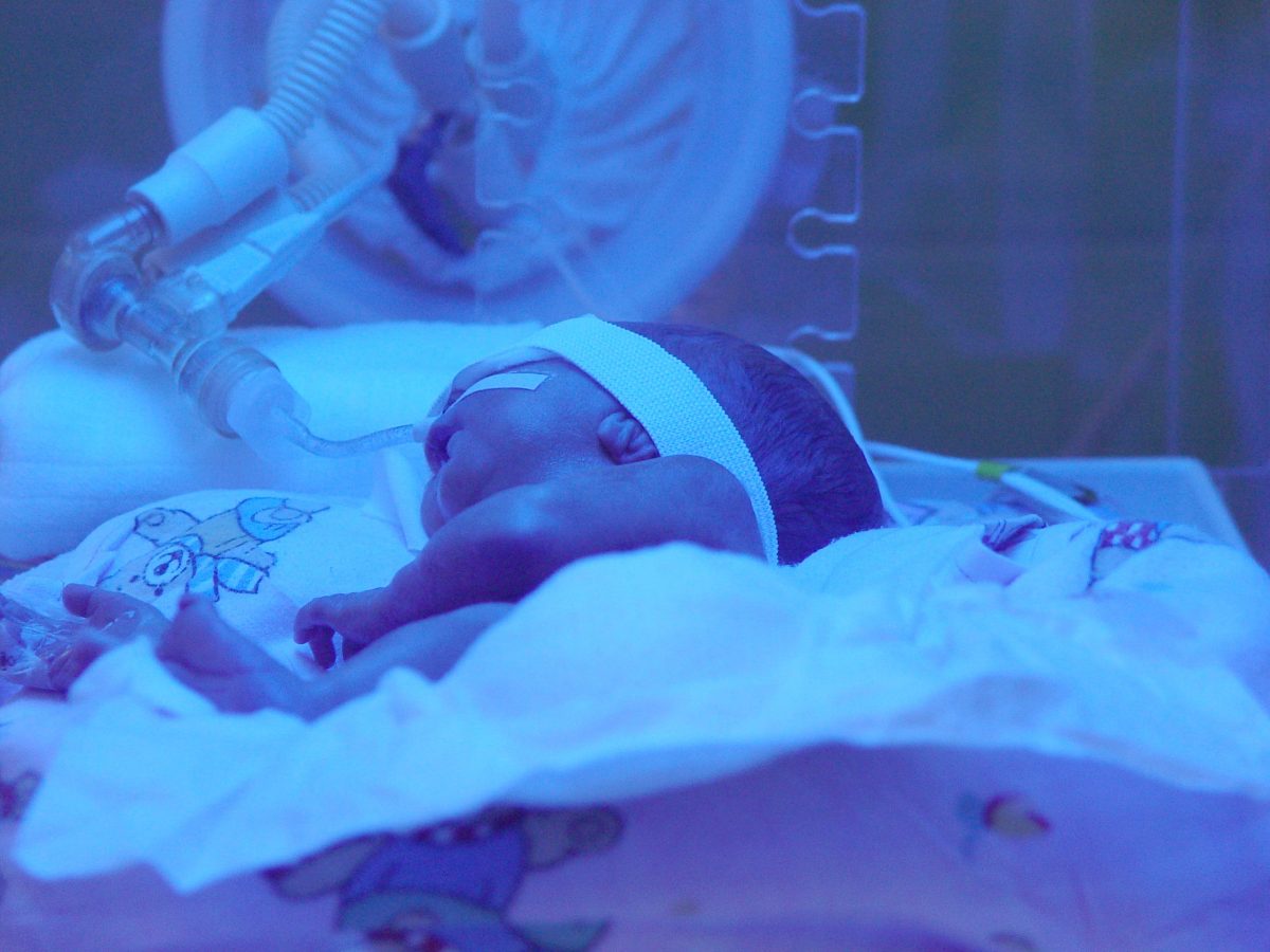 A newborn baby in an incubator
